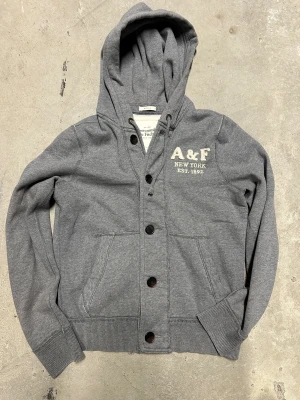Vintage Abercrombie kofta med knappar - Extremt eftertraktad och sällsynt vintage abercrombie hoodie med knappar! Grymt skick, inga defekter - ser exakt ut som på bild! Storlek M!. Skriv vid frågor!💬