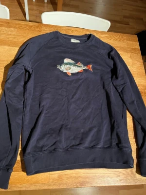 Foret tröja - En stilig tröja från foret med en fisk på. En riktig klassiker från foret. Storlek S. Inga slitage, enda som behövs är nog en tvätt så blir den som ny. 