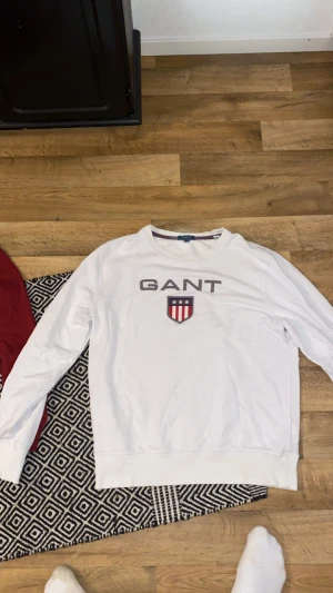 Vit GANT sweatshirt med tryck plus röd gant tröja storlek L - Vit sweatshirt från GANT med stort tryck och broderad logga på bröstet. Röd gant båda eller en för  samma pris 