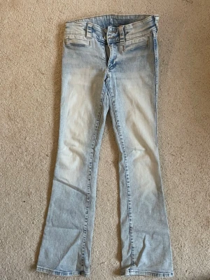 Low waist bootcut jeans - Supersnygga ljusblåa bootcut jeans med låg midja. Använda ett fåtal gånger, väldigt snyggt när dem inte har några bakfickor. Obs, finns en bläckpenna fläck på högre lår (se bild) den går inte att få bort, men den syns inte så tydligt. Om frågor eller fler bilder skriv till mig!