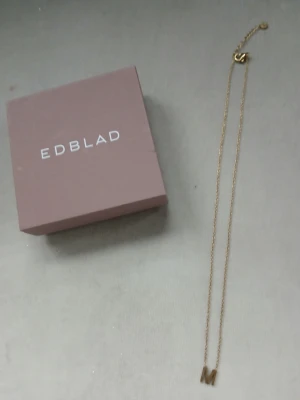 M halsband Letter fr. Edblad  - Bilderna visar ett halsband från Edblad med ett M-hänge i guld, men ingen väst finns med.