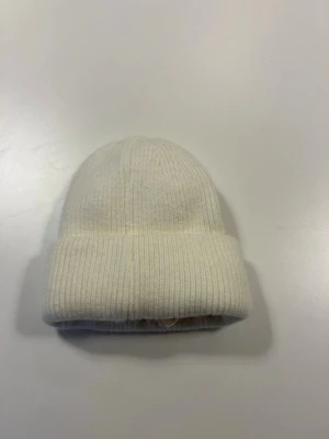 Vit/cream färgad stickad mössa med satin i  - Mössan är satinfodrad för att skydda håret från friss 