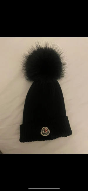 Svart M mössa med pälsboll - Svart mössa med svart päls