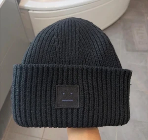 Svart stickad mössa Acne Studios - Säljer en svart ribbstickad mössa från Acne Studios.  Perfekt för dig som vill ha en clean och stilren look.