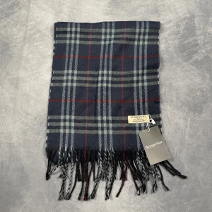 Burberry Halsduk - Skick: 7/10 (Vintage), begagnad, inga defekter. | Vad som ingår: Endast halsduken. | Ordinarie pris: +- 4000 SEK / 400 €. | ​​OBS: Halsdukarna finns i samma färgsättning men kan skilja sig något i modell eller detaljer, beroende på tillverkningsår eller kollektion