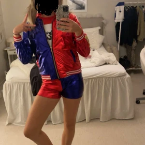 Harley Quinn dräkt - Säljer denna sjukt snygga Harley Quinn dräkt! Perfekt nu till halloween. Det som medföljer är shorts, t-shirt, jacka och en handske . Passar xs-s skulle jag säga