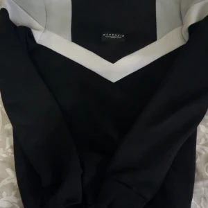 Svart sweatshirt från McKenzie - Svart sweatshirt från McKenzie med gråa detaljer i ett snyggt V-mönster över bröstet och axlarna. Tröjan har långärmade muddar och en klassisk rund hals. Perfekt för dig som gillar stilrena och sportiga plagg. Kan diskutera om priset!