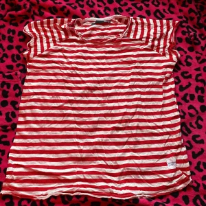 Rödvit randig t-shirt från 157 - Säljer en röd och vit randig t-shirt från 157 State Craft, storlek S. T-shirten har korta ärmar. Materialet är mjuk, perfekt för en chill och avslappnad stil. Märke och etikett syns tydligt på nederkanten.