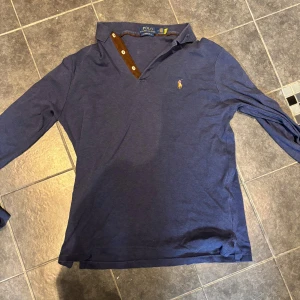 Blå långärmad pikétröja Polo Ralph Lauren - Blå långärmad piké ifrån Polo Ralph Lauren. Använd fåtal gånger. Mycket bra skick. Priset är inte hugget i sten och skriv vid funderingar.