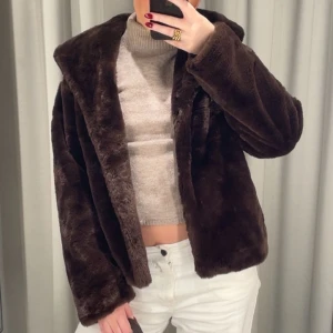 Mörkbrun pälsjacka  - Säljer en supermjuk och fluffig mörkbrun pälsjacka med oversized krage. Jackan har en loose passform och är perfekt för att hålla värmen under kyliga dagar. Den är helfärgad och har långa ärmar, vilket gör den extra mysig och trendig.