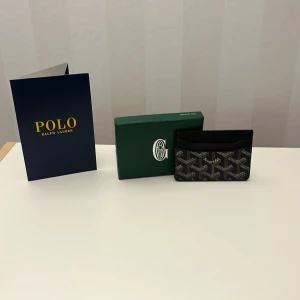  plånbok med mönster - Snygg plånbok f med klassiskt grafiskt mönster i svart, brunt och vitt. Insidan är gul och har en lyxig känsla med präglat skinn. Perfekt för kort och cash, och kommer med originalask. Paris-vibe och riktigt stilren design.