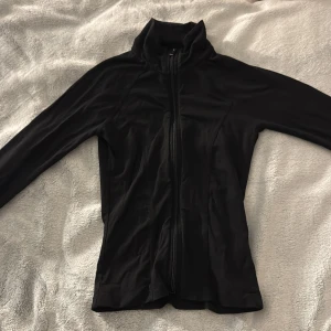 Svart ziptröja från Gina Tricot XS - Svart långärmad ziptröja från Gina Tricot i storlek XS. Tröjan har hög krage och hel dragkedja framtill.