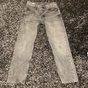 Grå relaxed jeans från H&M 32/32 - Säljer ett par gråa relaxed fit jeans från H&M i storlek 32/32. Jeansen har en rak passform med klassisk femficksdesign och knappgylf. Snyggt tvättad grå färg som ger en cool vintagekänsla. Perfekta för en avslappnad stil. Står ej för postens slarv och inga returer!