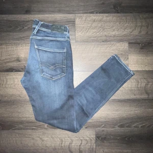 Replay Anbass jeans  - Snygga Replay Anbass jeans i mörkblå tvätt med coola slitningar och kontrastsömmar. Modellen har klassiska fem fickor, raka ben och normal passform. Materialet är mjukt jeans-tyg med stretch för extra komfort. Midja 38cm, längd 100cm. JAG SKICKAR INGA FLER BILDER PÅ NÄR JAG BÄR JEANSEN:) 16 