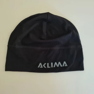 Svart merinoullmössa från Aclima - Svart tunn mössa från Aclima i 100% mjuk merinoull. Lätt och smidig modell som funkar grymt under hjälm eller jacka. Passar till mellan stora huvuden.