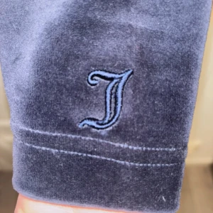 Juicy Couture  - Mysig lila långärmad tröja från Juicy Couture Black Label i mjuk sammet. Tröjan har en broderad J-detalj på ärmen och avslappnad passform. Perfekt för dig som gillar klassisk Y2K-stil och vill ha något riktigt comfy.Helt oanvänd Juicy couture tröja i storleken xl. Köpt för ungefär 3000kr