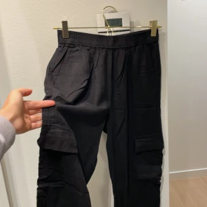 Svarta cargobyxor, linne | Levetē room  - Svarta cargobyxor/linnebyxor med elastisk midja och fickor på sidorna. Byxorna har en loose, straight och wide fit. 55% linne, 45% viskos 🖤