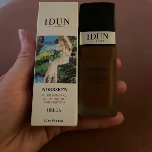 IDUN Minerals Norrsken Foundation Helga - IDUN Minerals Norrsken Pure Mineral Illuminating Foundation i nyansen Helga (deep 227). Flytande foundation i glasflaska med svart lock, 30 ml. Ger en naturlig lyster och är mineralbaserad. Kommer i en snygg förpackning med konstmotiv.