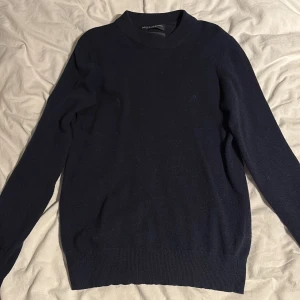 Marinblå kashmirtröja från Marc O’Polo - Snygg marinblå tröja från Marc O’Polo i mjuk kashmir. Klassisk rund hals och ribbade muddar vid ärmslut och nederkant. Perfekt för dig som gillar stilrena och bekväma plagg med lyxig känsla. Passar dig som vill ha en enkel men elegant look. Storlek S men passar bättre Xs