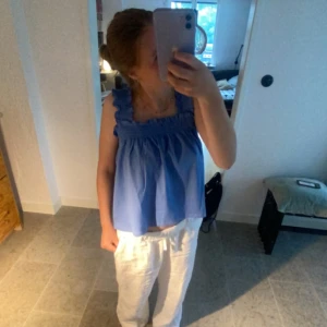 Blå linnetopp med volang - Säljer en fin ljusblå linnetopp med volangdetaljer vid axelbanden. 