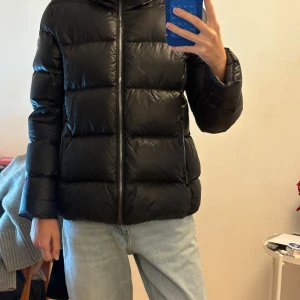 Svart pufferjacka från Colmar - Svart pufferjacka från Colmar med klassisk quiltad design och hög krage. Enbart en defekt vilket är en liten prick på insidan av jackan, annars är den i superfint skick. Köpt på kidsbrandstore för något år sedan för ca 4500kr. Storlek 16/172 och passar mig som är 170cm, skulle säga att den sitter som en XS. Pris går att diskutera. 