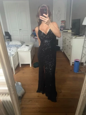 Svart glittrig långklänning med snörning - Balklänning med paljetter. Köpt utomlands. Storlek är TALLA EXTRA GRANDE. Jag på bilderna är 167.