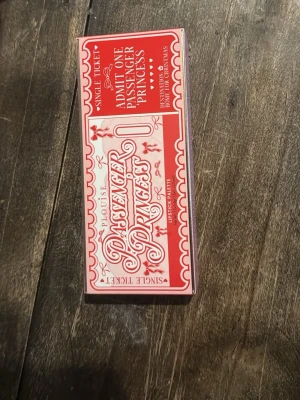 P.Louise Passenger Princess läppstiftspalett - Säljer en P.Louise Passenger Princess läppstiftspalett med 12 olika nyanser i nude, brunt, rött och rosa. Helt oanvänd! Paletten har en spegel och medföljer en rosa applikatorpensel. Perfekt för att mixa och matcha färger till läpparna. Snygg förpackning i rött och rosa.