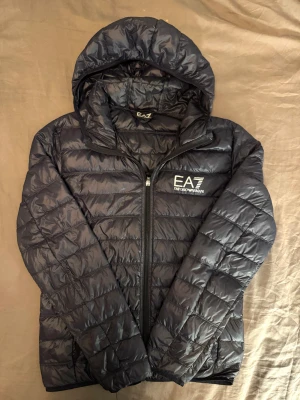 Mörkblå vindjacka från Armani - Mörkblå vindjacka från Armani med huva och dragkedja framtill. Original pris runt 2000kr
