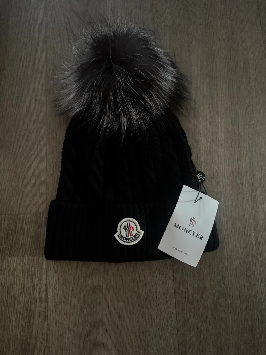 Svart  mössa med pälsboll
