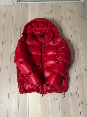 Ralph Lauren - Säljer en fet röd pufferjacka från Polo Ralph Lauren | Storlek L | Jättebra skick utan defekter | äkta med qr kod | modellen på bilden är 191cm / 75kg | pris går att diskutera vid snabb och enkel affär | passa på nu till vinter | inte använd så jättemycket |