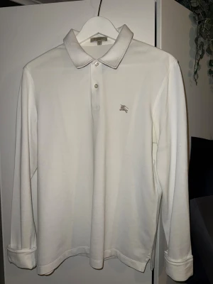 Burberry Piké - Vit långarmad piké från Burberry, inga defekter, riktigt snygg. Logga på bröstet och signatur mönstret vid kragen. Storlek S men passar både S och M. Skriv vid frågor! 
