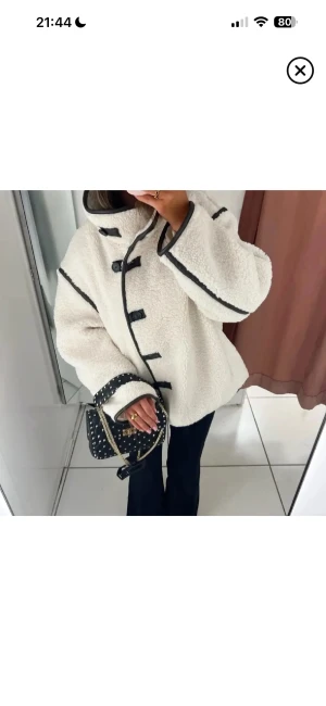 Vit teddyjacka med svarta detaljer - Superfin teddy jacka från hm, köpt här på plick! Ej använd av mig utan säljer då den var för liten! Skriv för frågor/ egna bilder!🥰🤍