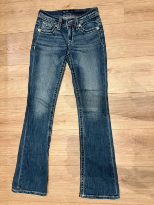 Miss me jeans bootcut - Snygga blå bootcut jeans från Miss Me med coola paljettdetaljer och broderier på bakfickorna. Dom är använda få gånger och är i väldigt fint skick💖 pris kan förhandlas! Storlek 24/32
