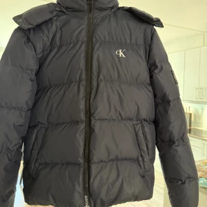 Svart pufferjacka från Calvin Klein - Mörkblå vinterjacka från Calvin Klein storlek xs. Ny skick köpt för 2700kr mitt pris 999