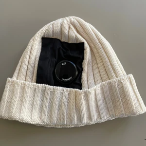 C.P. Company mössa - Benvit stickad mössa från C.P. Company. Garanterat äkta, köpt på NK i Sthlm, använd en säsong.  