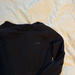 Svart croppad långärmad tröja ICANIWILL - Svart croppad långärmad tränings tröja från ICANIWILL, snygg och perfekt till gymmet!