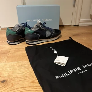 Philippe Model Trainers - Snygga trainers från Philippe Model i marinblått och grönt med vita detaljer. Sparsamt använda, då skicket är väldigt bra, 8/10 skick. Självklart ingår originalbox, dustbag och tag. Perfekta inför hösten/vintern. Hör av vid frågor! 
