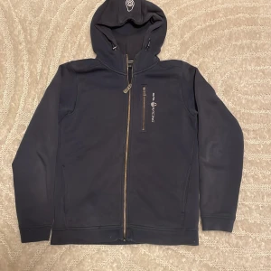 Sail racing zip hoodie - Snygg marinblå tröja från Sail Racing med heldragen dragkedja. Tröjan är lite solblekt vid innerkurvan ( se bild)  men annars bra skick😊. Tveka inte på att höra av er vid frågor