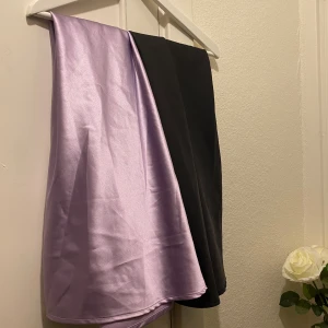 Ljuslila/svart satin-kjol - 2 stycken satin kjolar från Gina tricot. En i svart och en i lila. Storlek L på båda