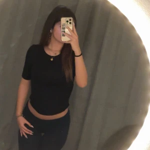 Svart topp - Svart topp från H&M med korta ärmar och en uppdragen detalj vid sidorna. Säljer då den inte används längre🥰