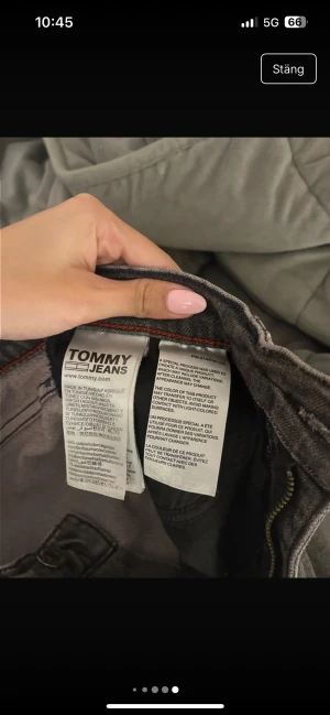 Snygga bootcut jeans med hål  - Säljer ett par grå jeans från Tommy Jeans med självgjorda slitningar. Storlek 27/34 men brukar själv ha 25/30 i storlek dock är de milt lösa så skulle säga att de passar någon som har 25/26 i midja och 30/32 i längd 