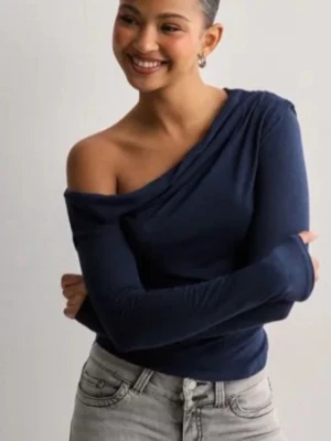 Mörkblå oneshoulder topp - Snygg mörkblå topp med oneshoulder-design och långa ärmar. Köpt från Nelly men aldrig använd då jag inte gilla hur den satt på mig och den var lite stor. 