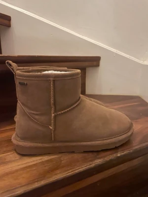 Bruna waterproof boots med ullfoder - Säljer ett par bruna boots med mjukt ull foder på insidan och platt sula. Skorna är vattentäta. Perfekta för kalla och blöta dagar. Storlek 38 (24.8 cm). Sparsamt använda men se bilder för defekter, inköpta för 800 kr