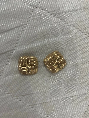 Superfina guld örhänge från ur&penn - Bilden visar inga västar utan ett par guldfärgade örhängen i flätad design.