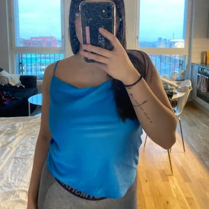 Blå satin linnetopp fr. H&M i strl 32 - Blå satin topp / linne från i strl 32. Säljes pga att den ej kmr till användning längre, ingick i någon specialkollektion. Utgången ur sortimentet. Säljes för 50 kr exkl. frakt. Kan fraktas eller mötas upp i Göteborg. Finns på fler sidor! 