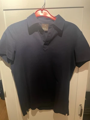 Mörkblå piké Oscar Jacobson - En klassisk mörkblå piké från Oscar Jacobson, mycket bra skick