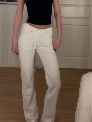 Vita straight jeans  - Säljer ett par vita jeans från Never Denim i modellen Low Straight. De har midwaist och raka ben, dessutom helt nya!😊Jag är 172cm. Storlek W25L32