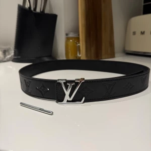Svart L-V skärp med silverdetaljer - Säljer ett svart L-V bälte. Storlek 115cm. Skriv vid minsta intresse!