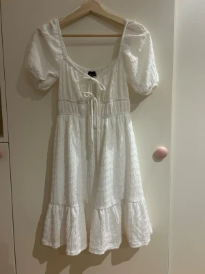 Vit kortklänning från Gina Tricot - Supersöt vit kortklänning från Gina Tricot med puffärmar. Endast använd på en skolavslutning, helt slutsåld och orginalpris är 399kr (därav priset)