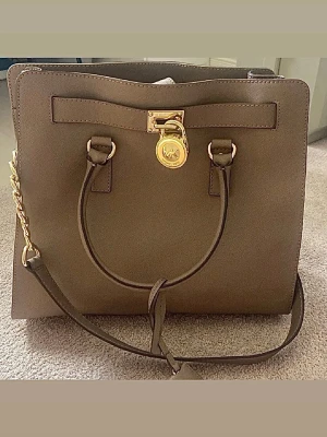 Michael Kors väska - Michael Kors väska i brunt skinn med guldfärgade detaljer.